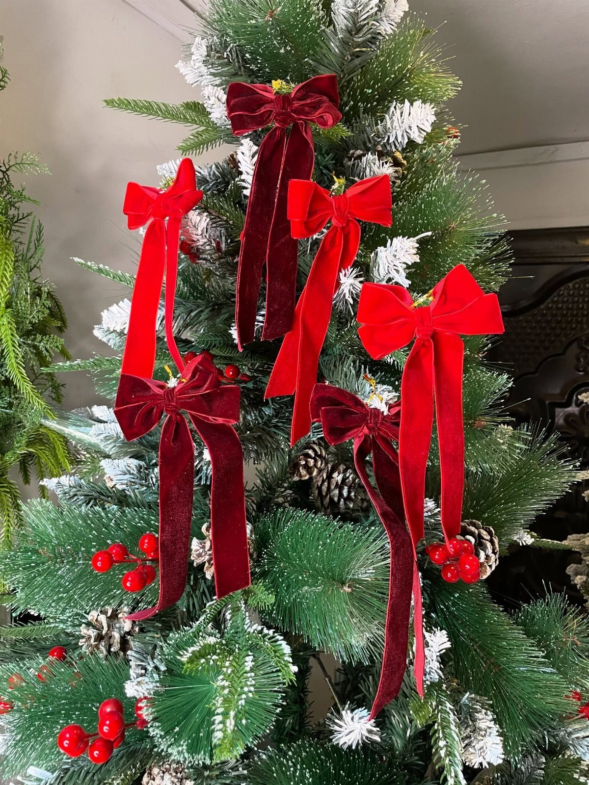 90s Christmas Tree Decor: 8 Ideas for Retro Holiday Charm 5 Red velvet bows tied onto the branches of a frosted green Christmas tree.