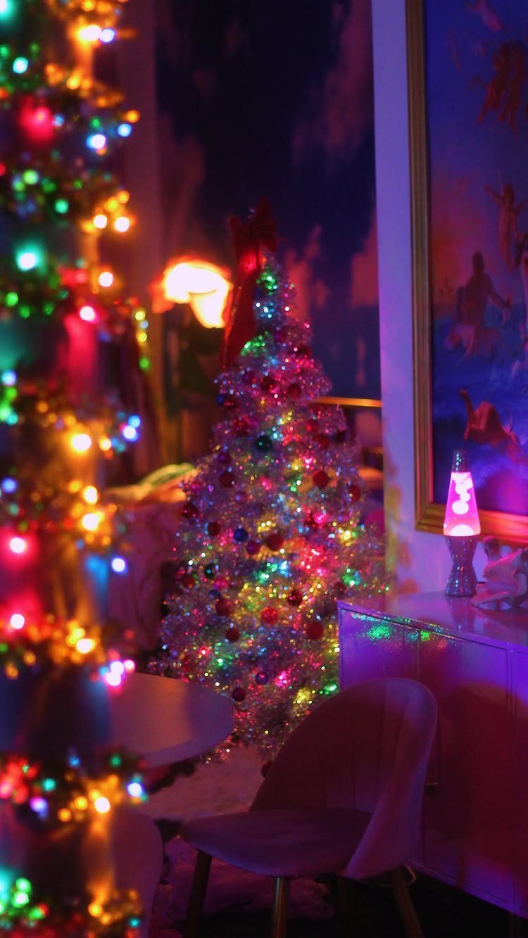 90s Christmas Tree Decor: 8 Ideas for Retro Holiday Charm 1 Two glowing Christmas trees decorated with colorful lights and ornaments in a dark room.
