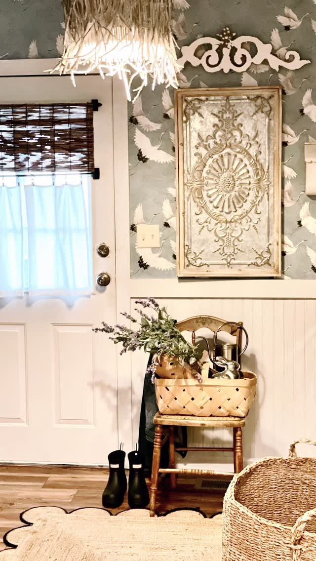 Bamboo shade and light blue curtains hanging over a white door in a decorated room.