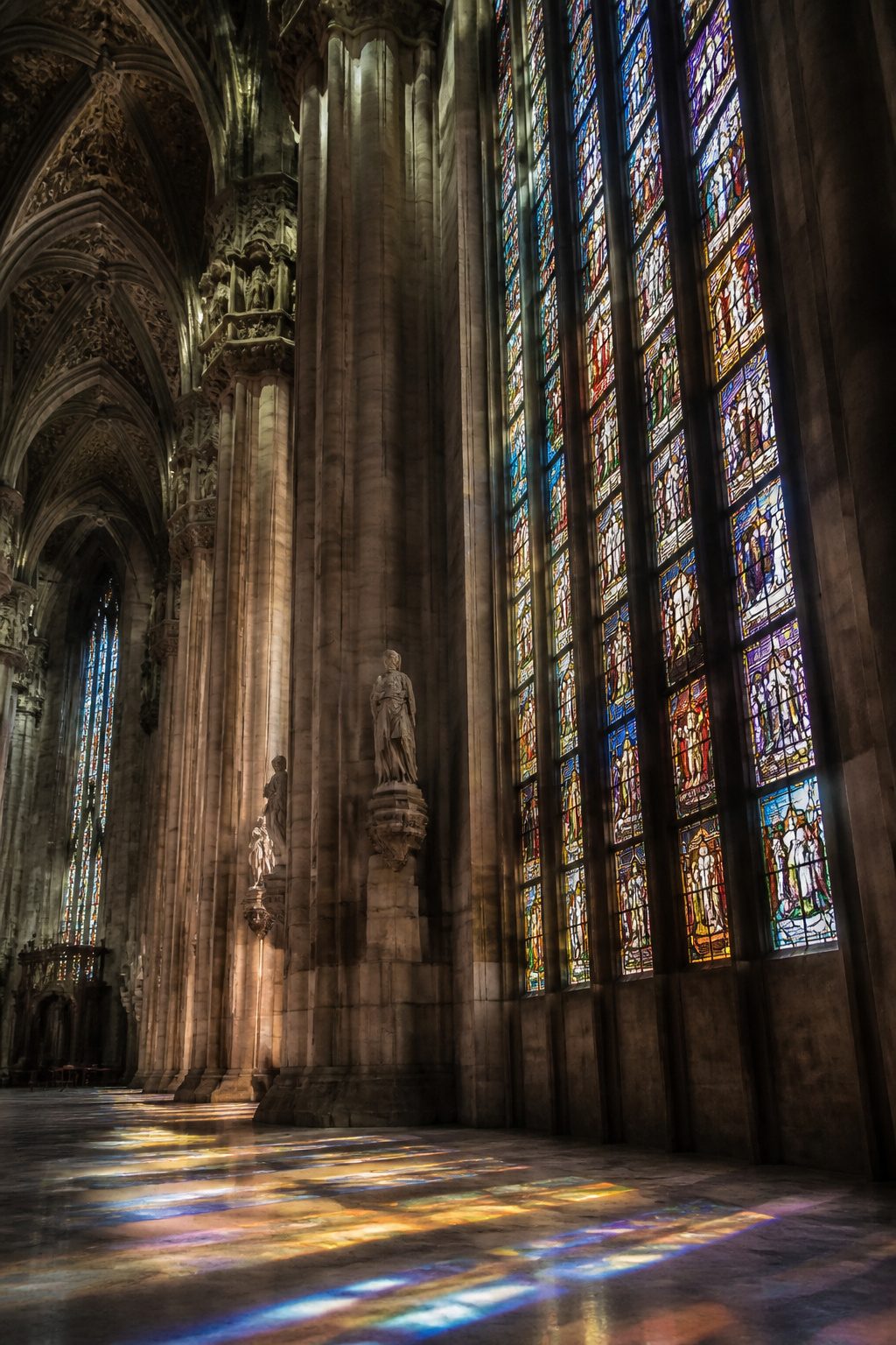 Beautiful Stained Glass Windows: 14 Sites That Changed Light Forever 14 Large stained glass windows displaying biblical narratives in Milan Cathedral.