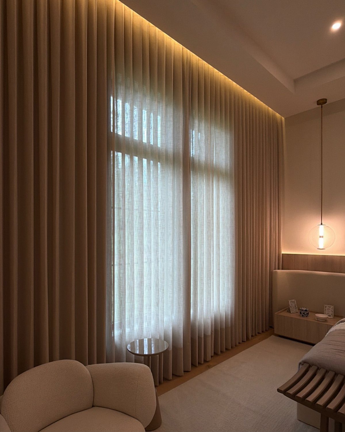 10 Bedroom Window Decor Ideas for Every Wall Height 3 Beige floor-to-ceiling curtains hanging from a recessed ceiling track in a modern bedroom.