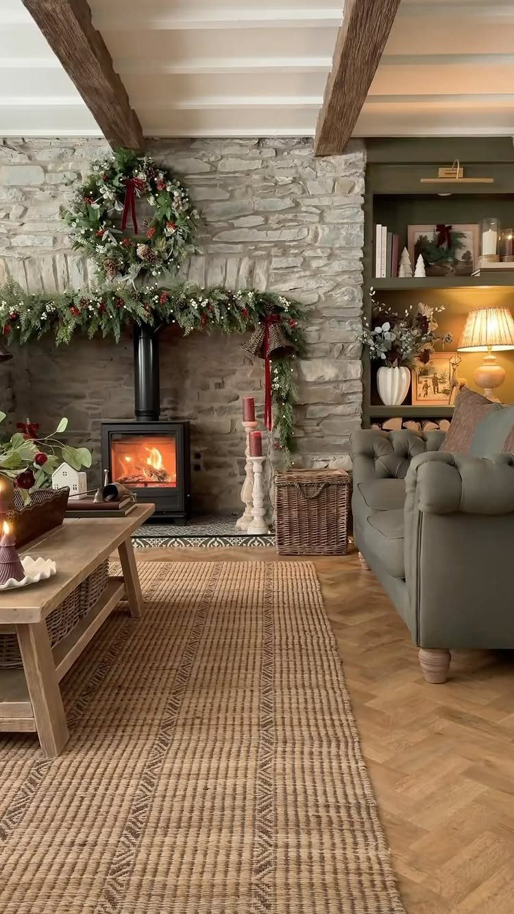 25 Christmas Decor Apartment Ideas That Maximize Space 17 A stone fireplace with a lit stove, decorated with a green garland and wreath.