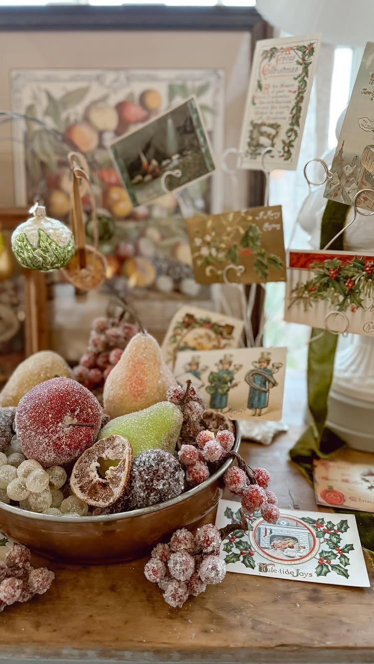 21 Christmas Decor Inspiration Ideas for Your Whole Home 2026 20 Frosted artificial fruit in a bowl with vintage holiday cards and a green ornament.