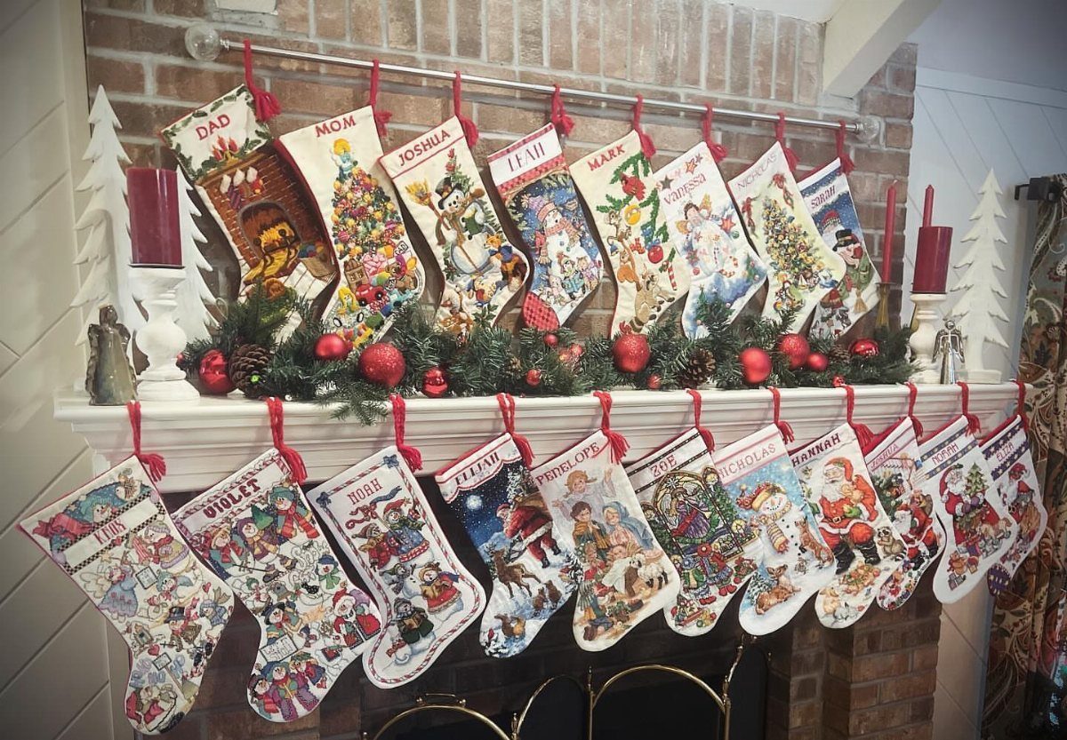 11 Christmas Home Decorating Ideas for 2026: Garlands to Lanterns 7 Many colorful patterned Christmas stockings hanging from a decorated fireplace mantel.