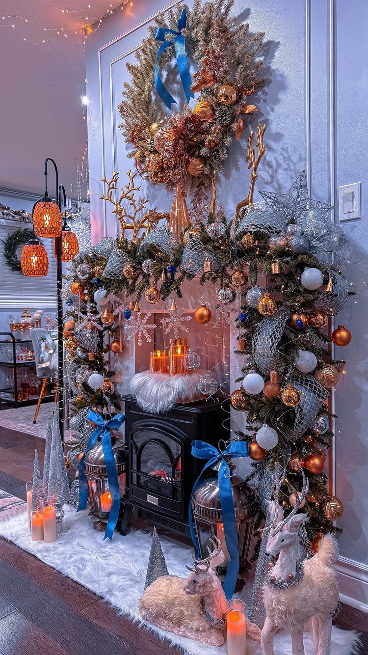 Decorated Christmas mantel with a large wreath, greenery, ornaments, and reindeer figurines on the hearth.