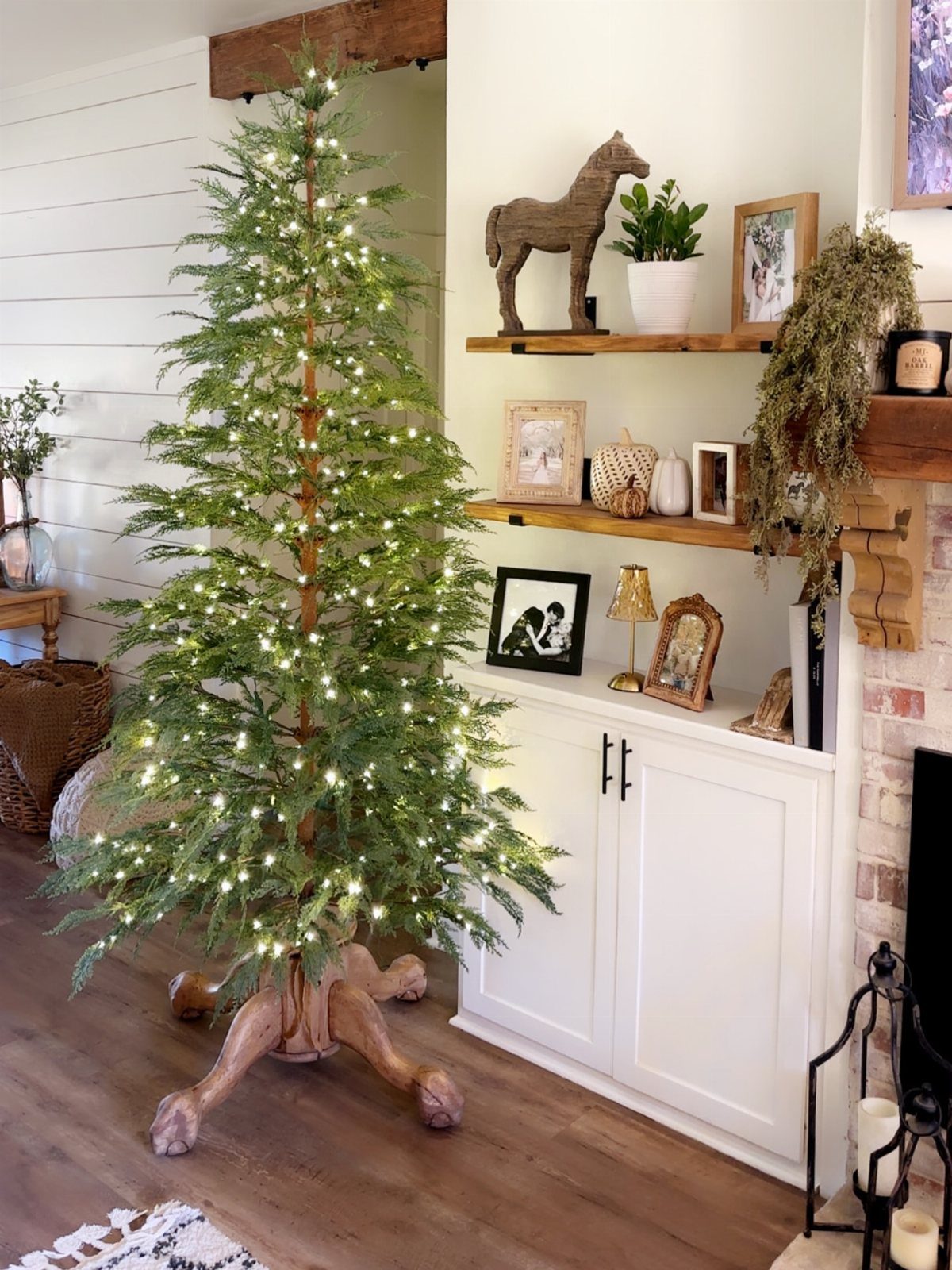 20 Christmas Rustic Decor Ideas for a Warm Holiday Home 1 A lit evergreen Christmas tree sits on a decorative carved wooden tree stand.