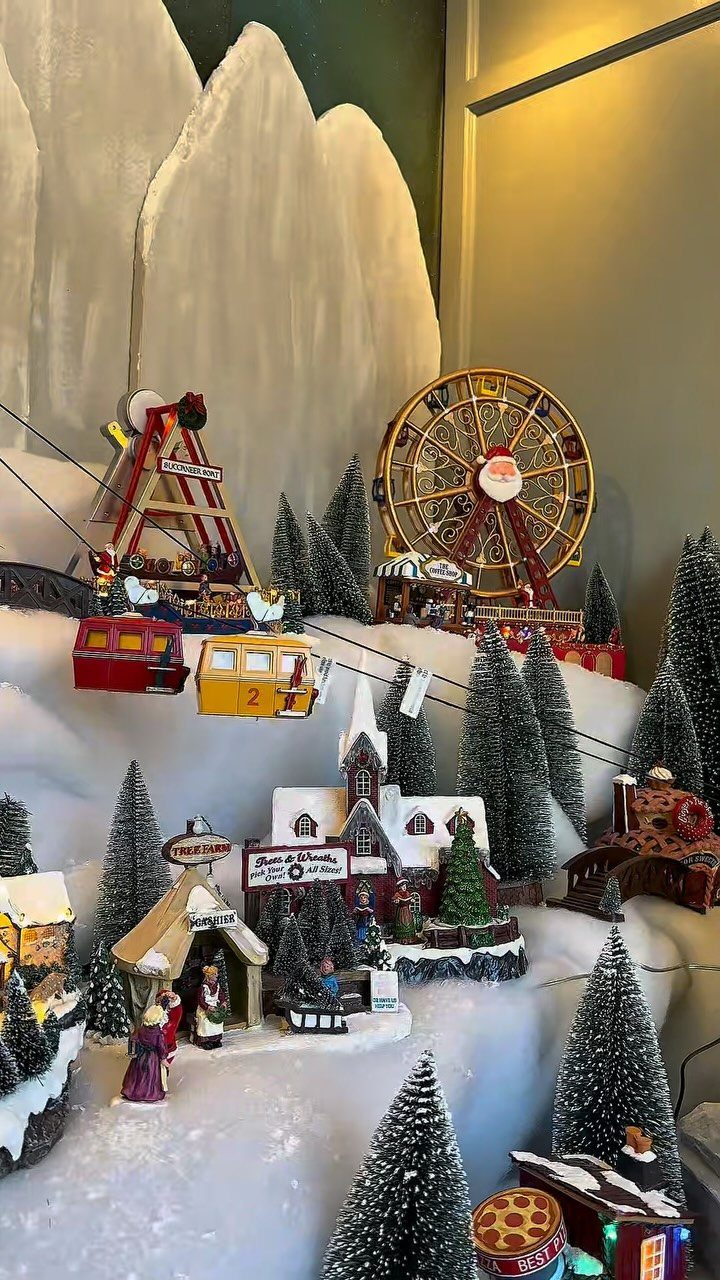 19 Christmas Village Ideas for Displaying a Miniature Scene 16 Miniature Christmas village display featuring a Ferris wheel, ski lift, and tiny snow-covered houses.
