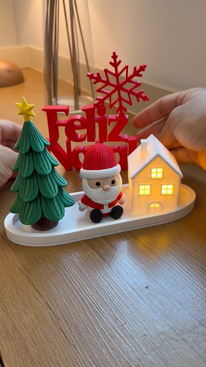 19 Christmas Village Ideas for Displaying a Miniature Scene 11 Miniature Christmas village with Santa, a tree, and a glowing house on a white tray.