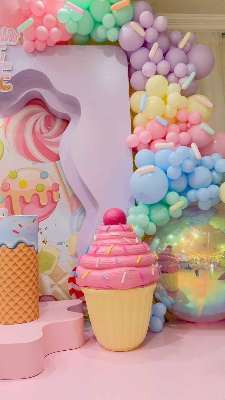 DIY Candyland Decorations: 10 Creative Party Ideas 2 Pastel balloon garland and large cupcake prop decorating a candy-themed party setup.