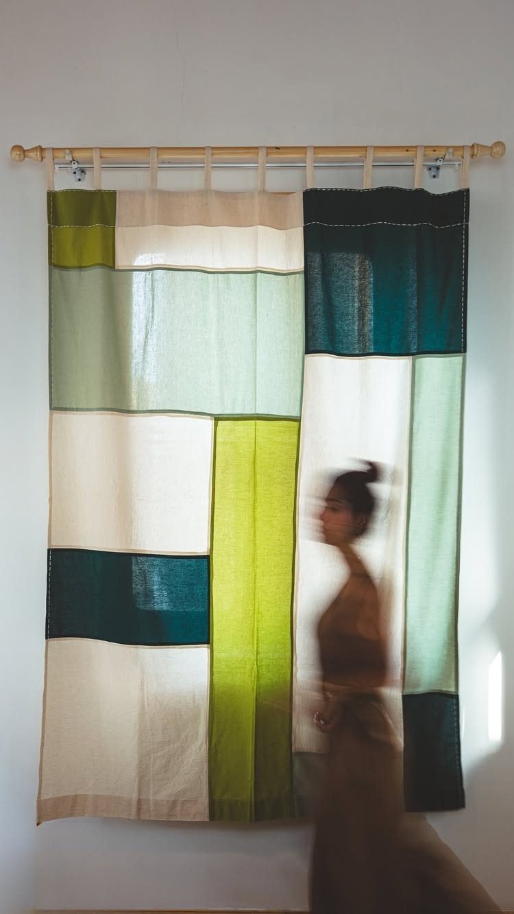 10 DIY Window Covering Ideas for a Quick Upgrade 4 Patchwork curtains made of green and cream fabric rectangles hanging from a wooden rod.