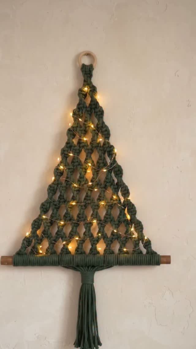 Hanging Christmas Tree: 6 Ideas for Small Spaces 3 Green macrame Christmas tree wall hanging decorated with glowing warm fairy lights.
