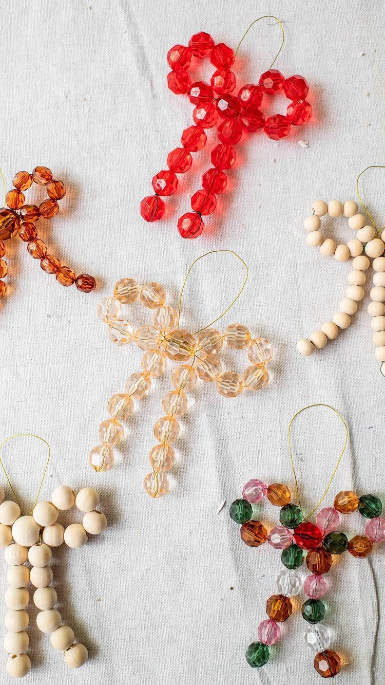 Homemade Christmas Decorations: 17 Easy Projects for 2026 4 Beaded bow ornaments in various colors scattered on a white textured background.
