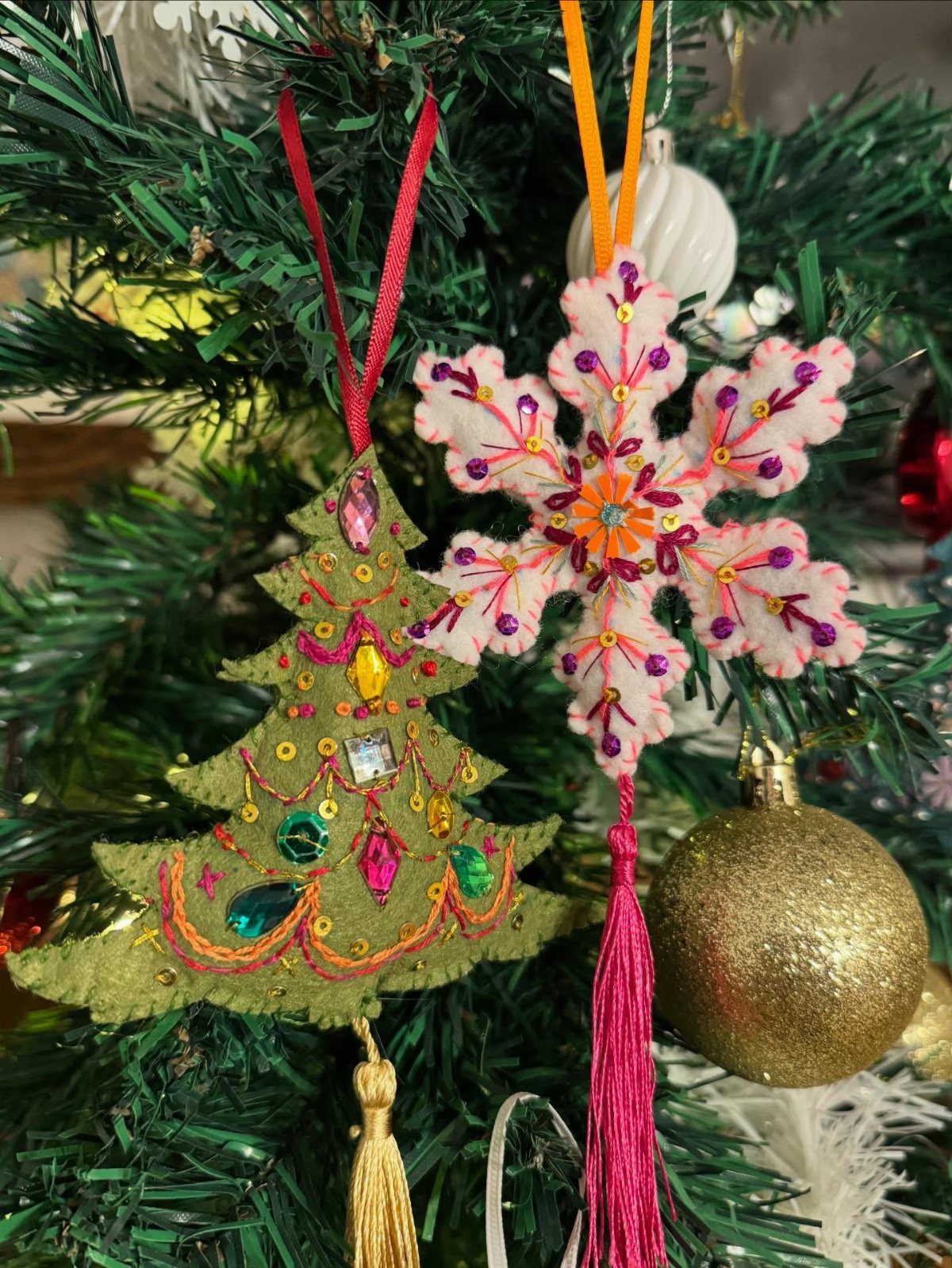 Homemade Christmas Decorations: 17 Easy Projects for 2026 10 Felt Christmas tree and snowflake ornaments decorated with beads hanging on a green tree.