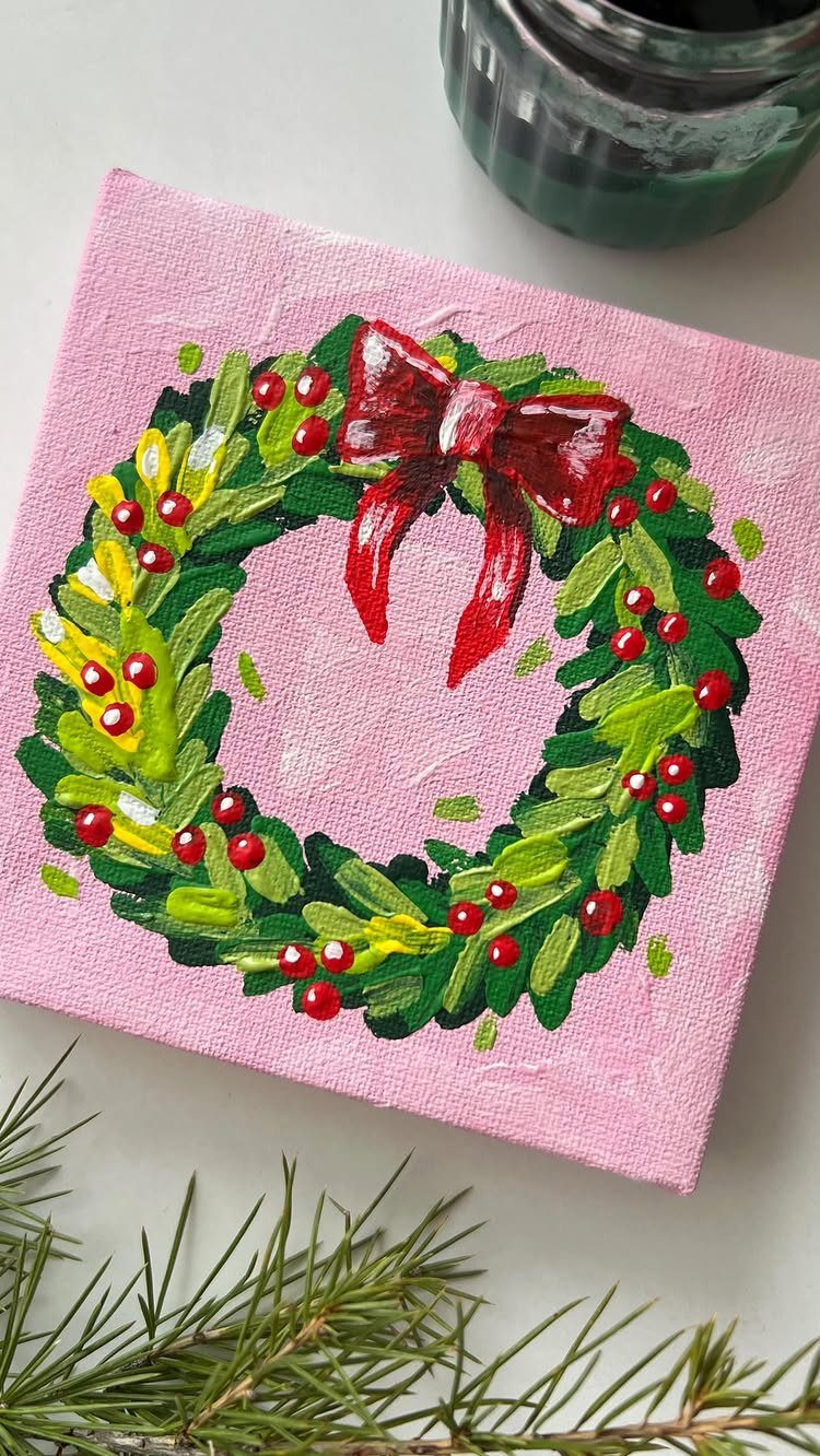 Homemade Christmas Decorations: 17 Easy Projects for 2026 16 A hand-painted Christmas wreath with a red bow on a pink canvas background.