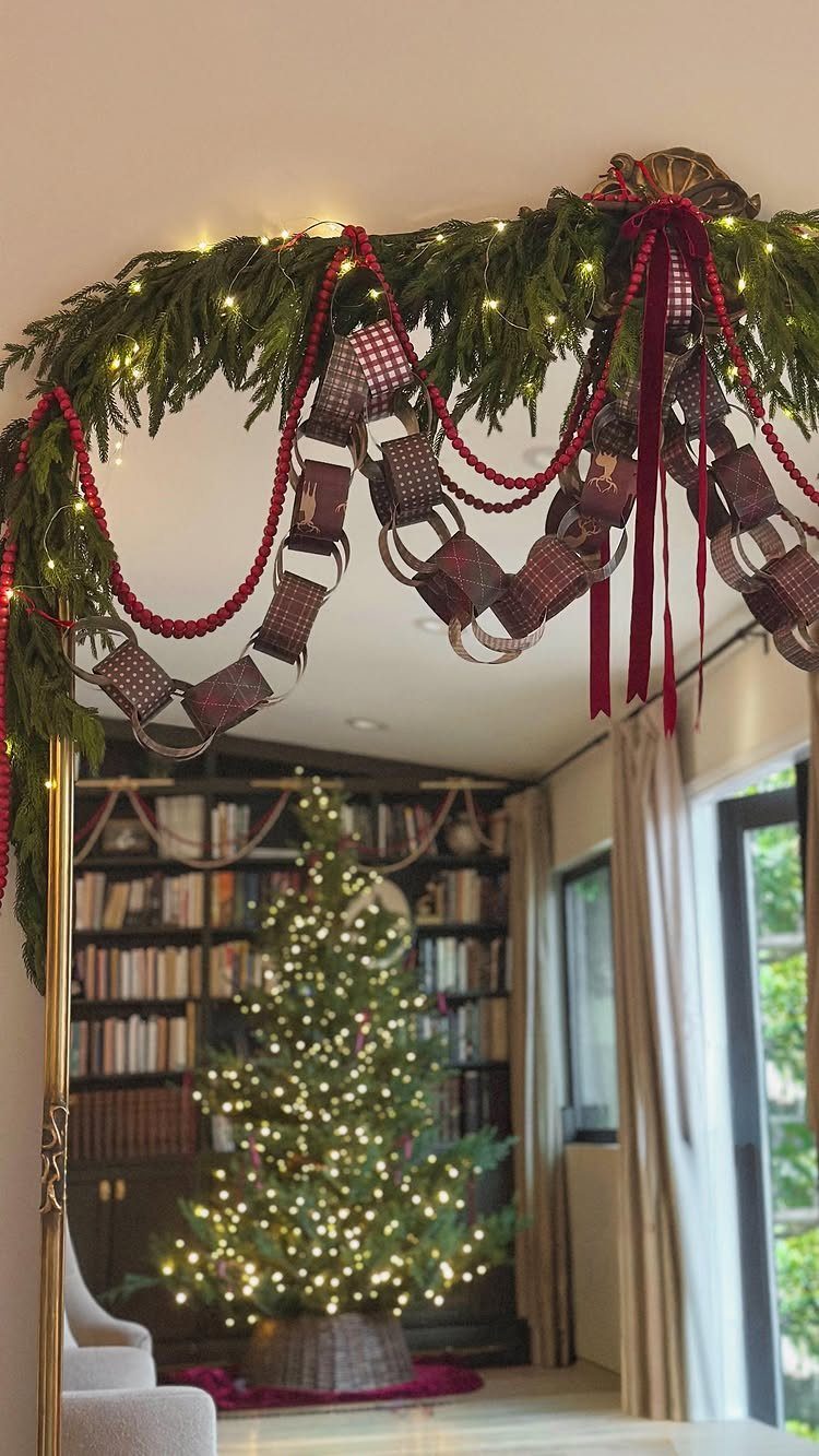 Homemade Christmas Decorations: 17 Easy Projects for 2026 5 Paper chain garland with red beads and pine branches hanging over a doorway near a Christmas tree.