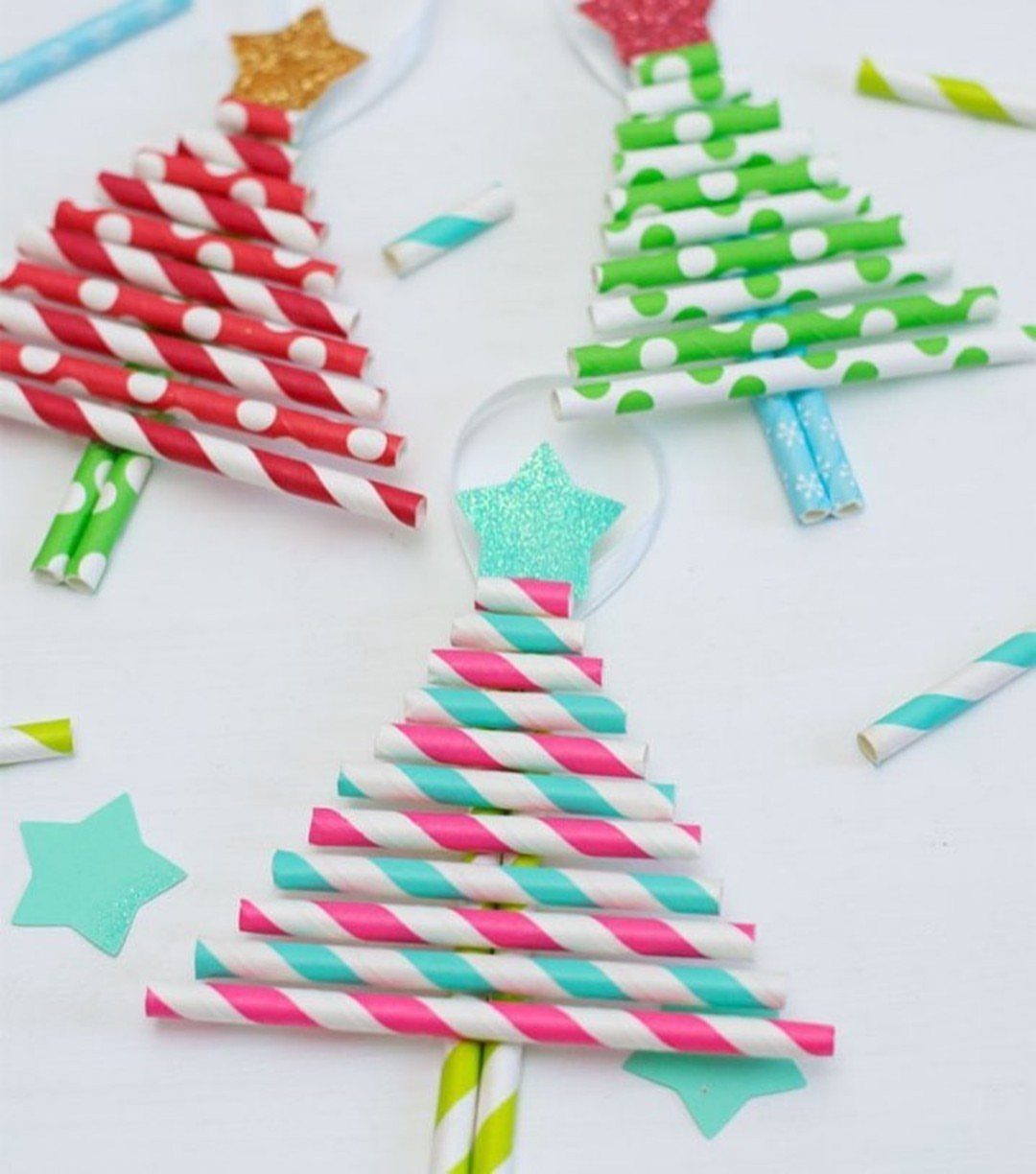Homemade Christmas Decorations: 17 Easy Projects for 2026 1 Three small Christmas trees constructed from colorful patterned paper straws with glittery star toppers.
