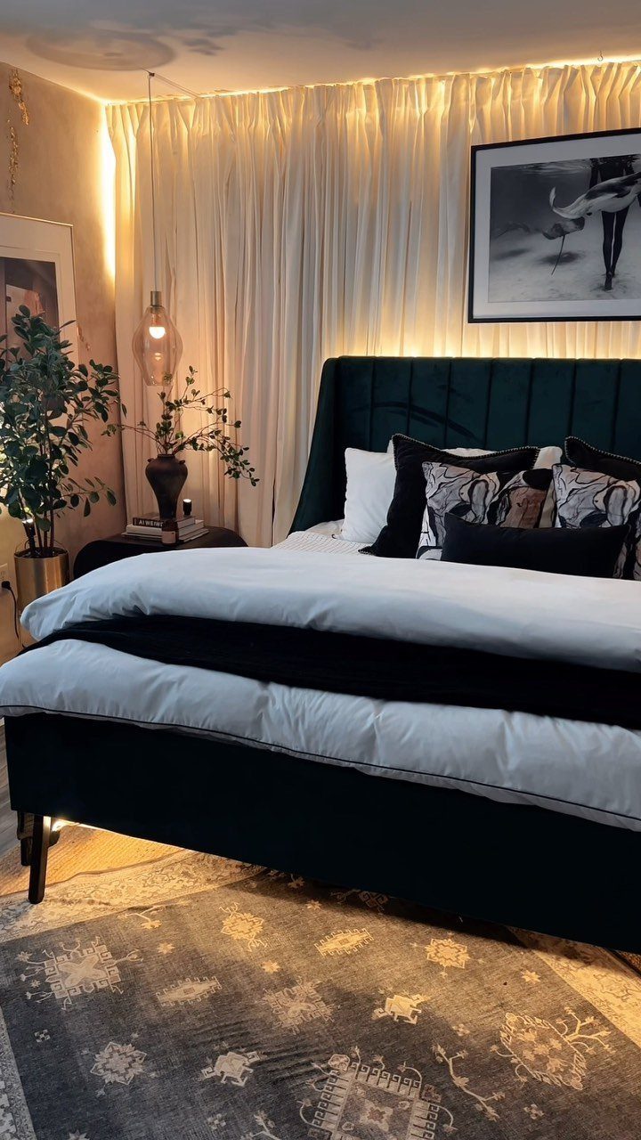 13 House Curtains Ideas for Every Style 12 Cream sheer curtains hanging behind a bed with a dark green velvet headboard.