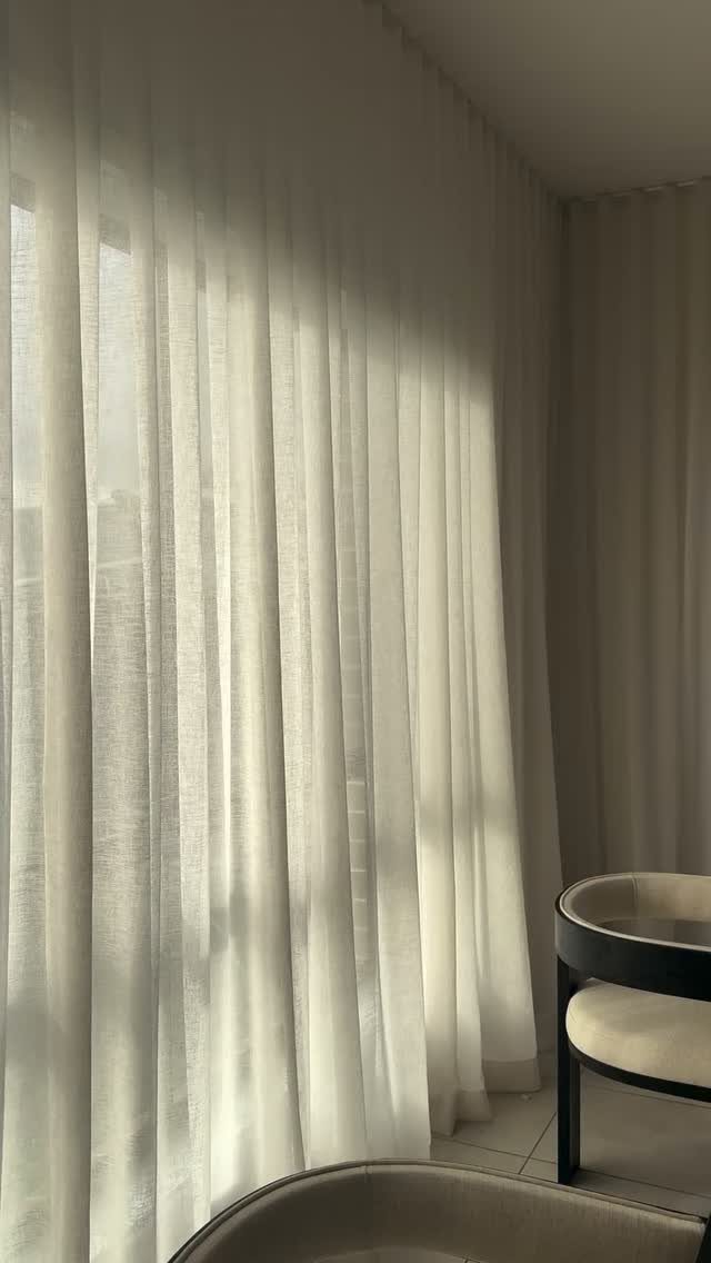 13 House Curtains Ideas for Every Style 7 Sheer off-white linen curtains hanging from a ceiling track in a sunlit room.