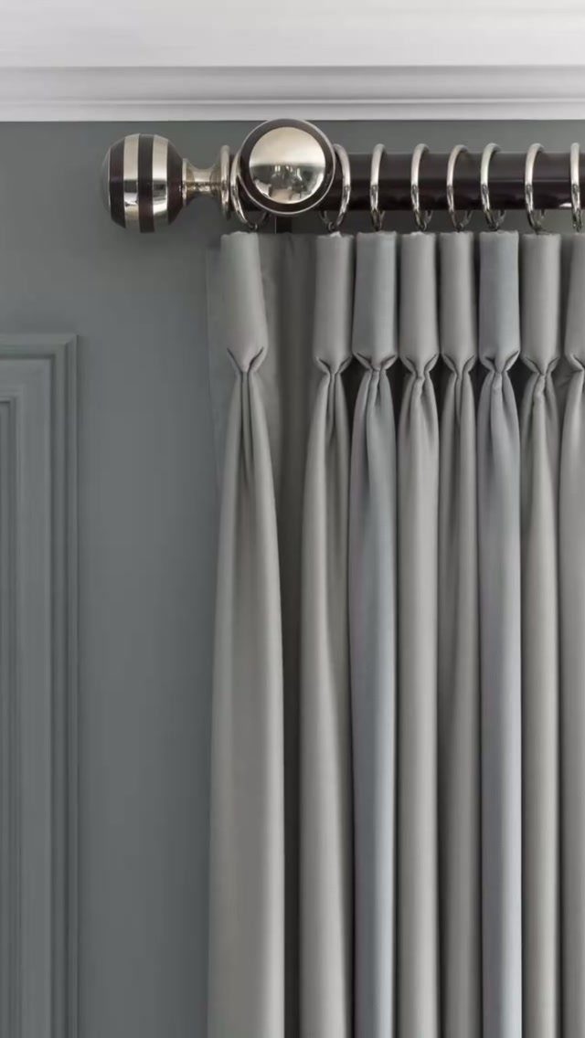 13 House Curtains Ideas for Every Style 4 Grey pinch pleat curtains hanging from a decorative silver and black metal curtain rod.