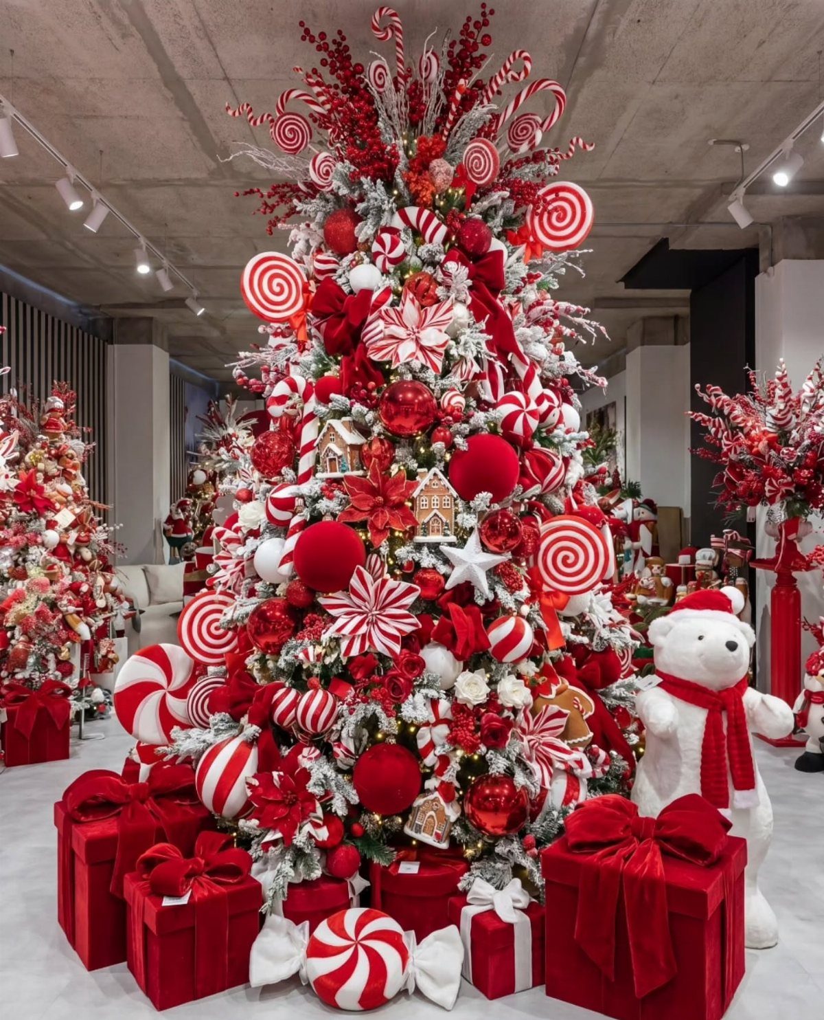 A Christmas tree decorated with red and white candy-themed ornaments and surrounded by red gift boxes.
