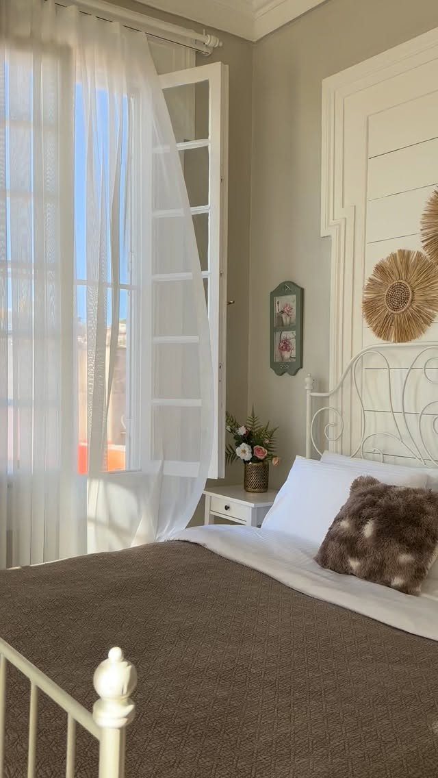 22 Unique Bedroom Curtains for Layered, Canopy and Lighted Styles 15 Sheer white curtains hanging over an open window in a sunlit bedroom with a white bed frame.