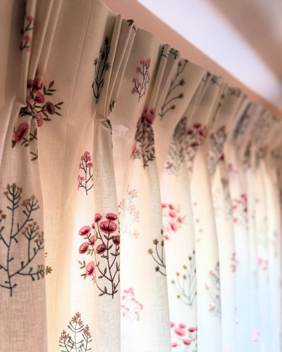 22 Unique Bedroom Curtains for Layered, Canopy and Lighted Styles 19 Cream curtains with a delicate pink floral and green stem pattern hanging in folds.