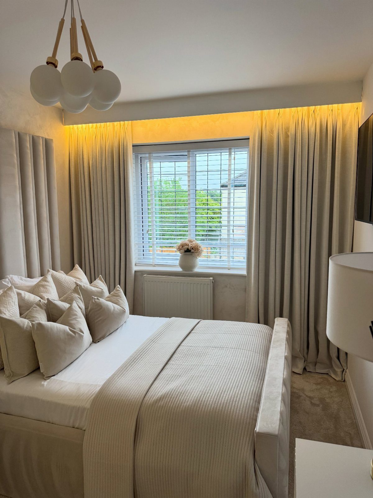 22 Unique Bedroom Curtains for Layered, Canopy and Lighted Styles 22 Neutral curtains hanging from a lit ceiling cove above a bed with white pillows.
