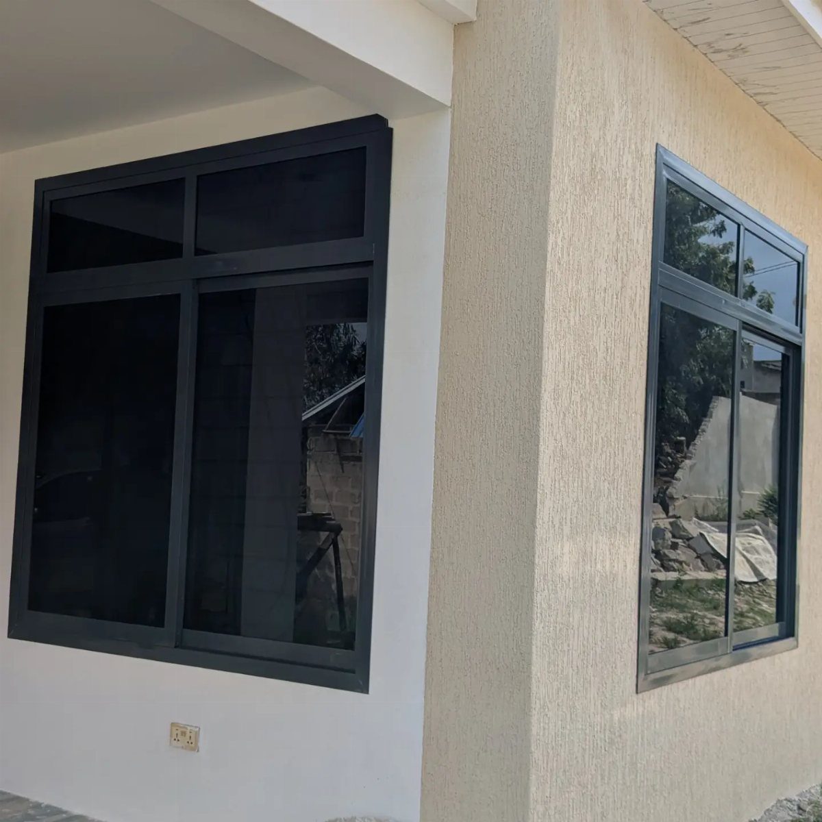 Black-framed windows installed on the white and beige exterior walls of a building.