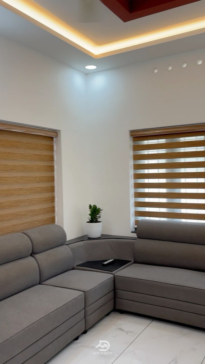 Window Blinds for Living Room: 11 Photo Ideas 8 Wooden zebra blinds covering two windows above a grey sectional sofa in a living room.