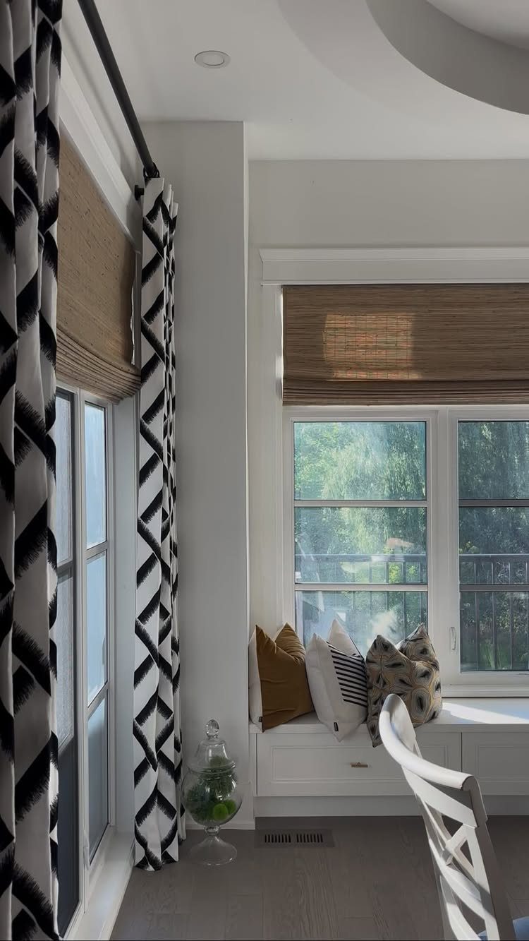 10 Window Dressing Ideas for Shutters, Shades and Blinds 7 Woven wood shades installed over a window above a white built-in window seat with pillows.