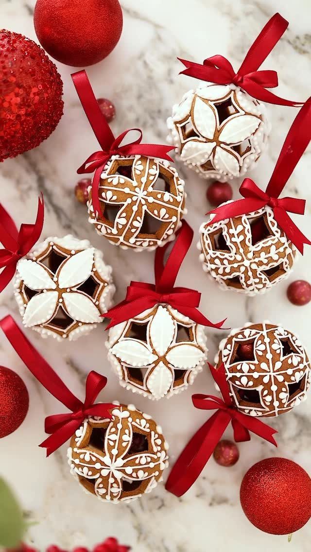 32 Xmas Gifts to Make: Easy Ideas for Handmade Holiday Presents 23 Gingerbread ornaments with white icing patterns and red ribbons on a marble surface.