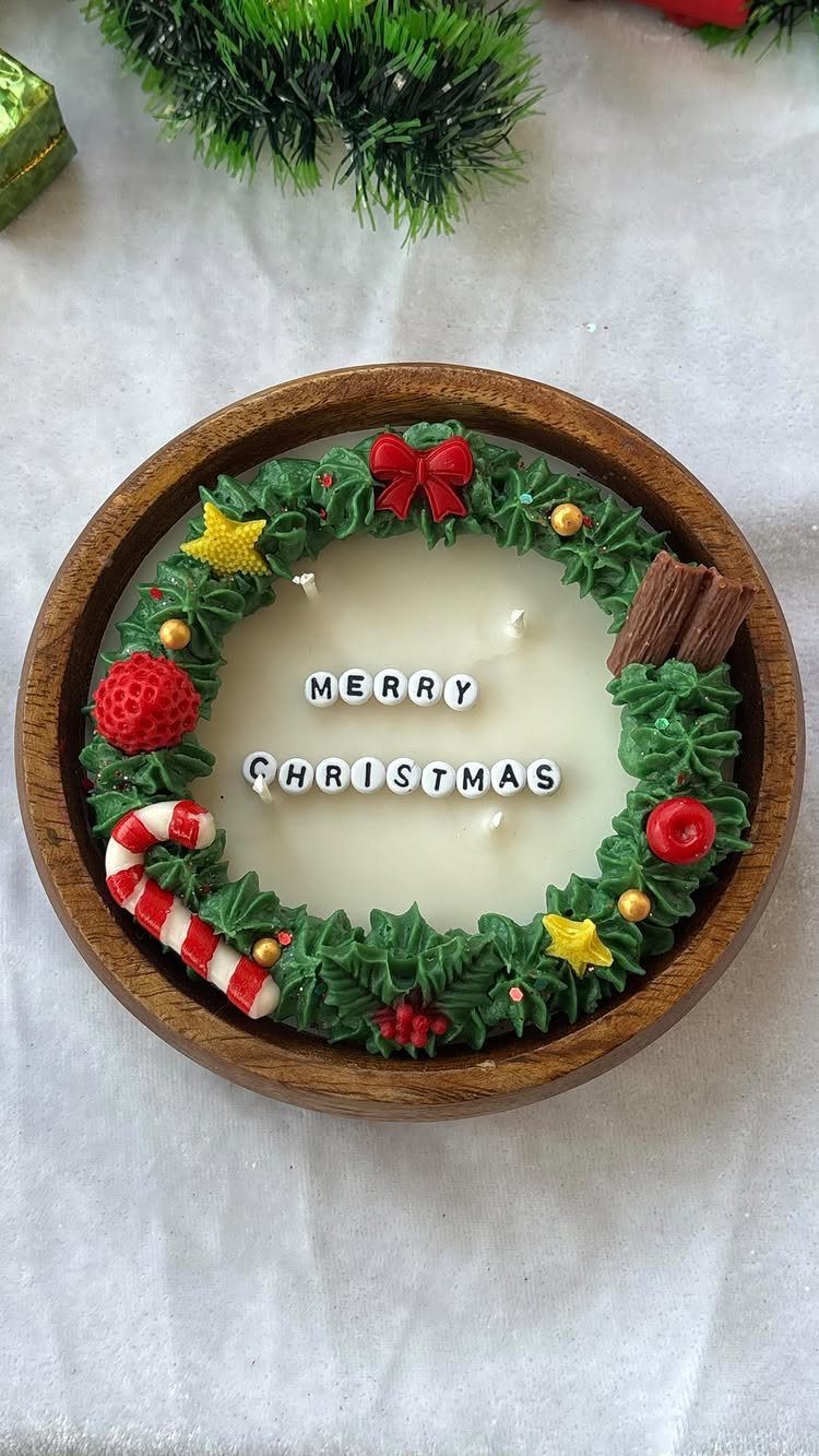 32 Xmas Gifts to Make: Easy Ideas for Handmade Holiday Presents 21 A decorative Christmas wreath candle in a wooden bowl with Merry Christmas letter beads.