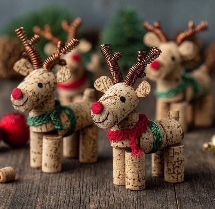 32 Xmas Gifts to Make: Easy Ideas for Handmade Holiday Presents 7 Three wine cork reindeer figurines with wire antlers and colorful yarn scarves on wood.
