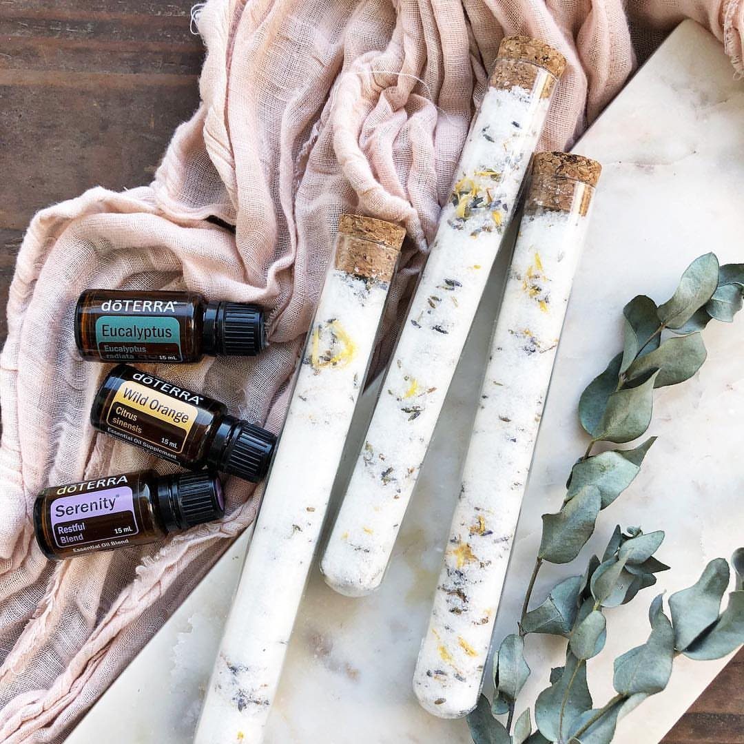 32 Xmas Gifts to Make: Easy Ideas for Handmade Holiday Presents 4 Three glass tubes filled with floral bath salts resting on marble next to essential oils.