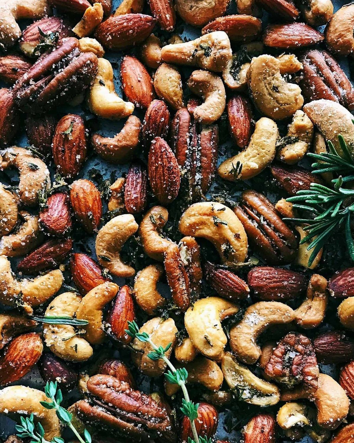 32 Xmas Gifts to Make: Easy Ideas for Handmade Holiday Presents 9 Spiced almonds, cashews, and pecans seasoned with herbs scattered on a dark surface.